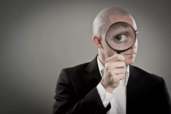 businessman-magnifying-glass-12539467.jpg